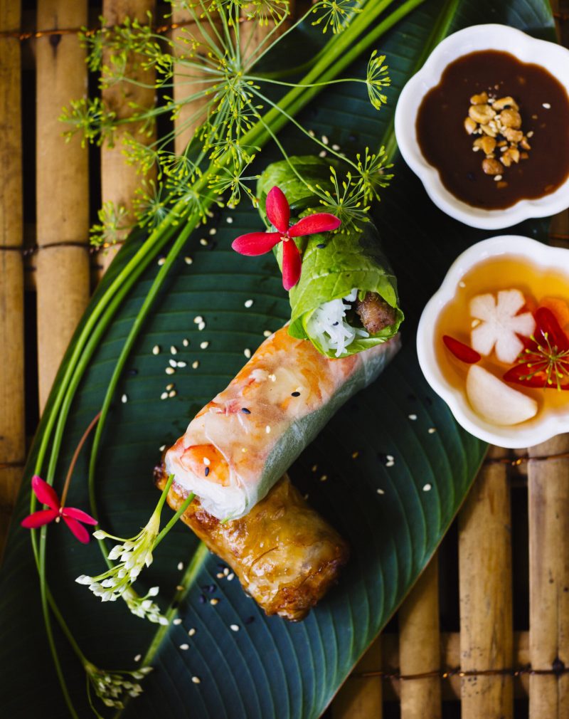 High angle close up of Vietnamese spring rolls served on a banana leaf.